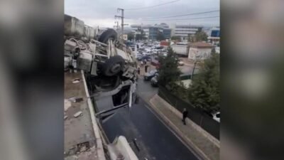 İzmir'de yağmurun yağmasıyla kayganlaşan yolda kontrolden çıkarak, 12 metrelik viyadükte asılı