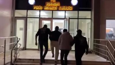 Bornova'da kendilerini polis olarak tanıtarak girdikleri evde iki kişiyi silahla