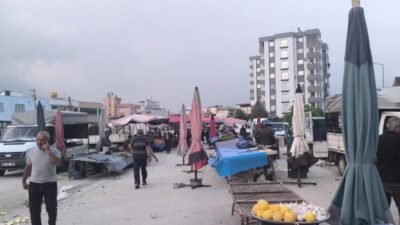 Kadirli ilçesindeki semt pazarında bir yurttaşın yerdeki yiyecekleri toplaması ekonomik