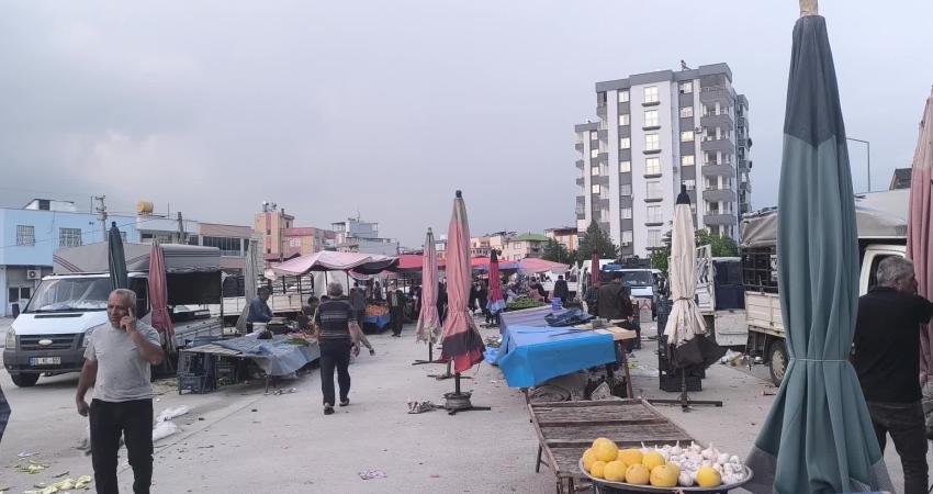 Kadirli ilçesindeki semt pazarında bir yurttaşın yerdeki yiyecekleri toplaması ekonomik